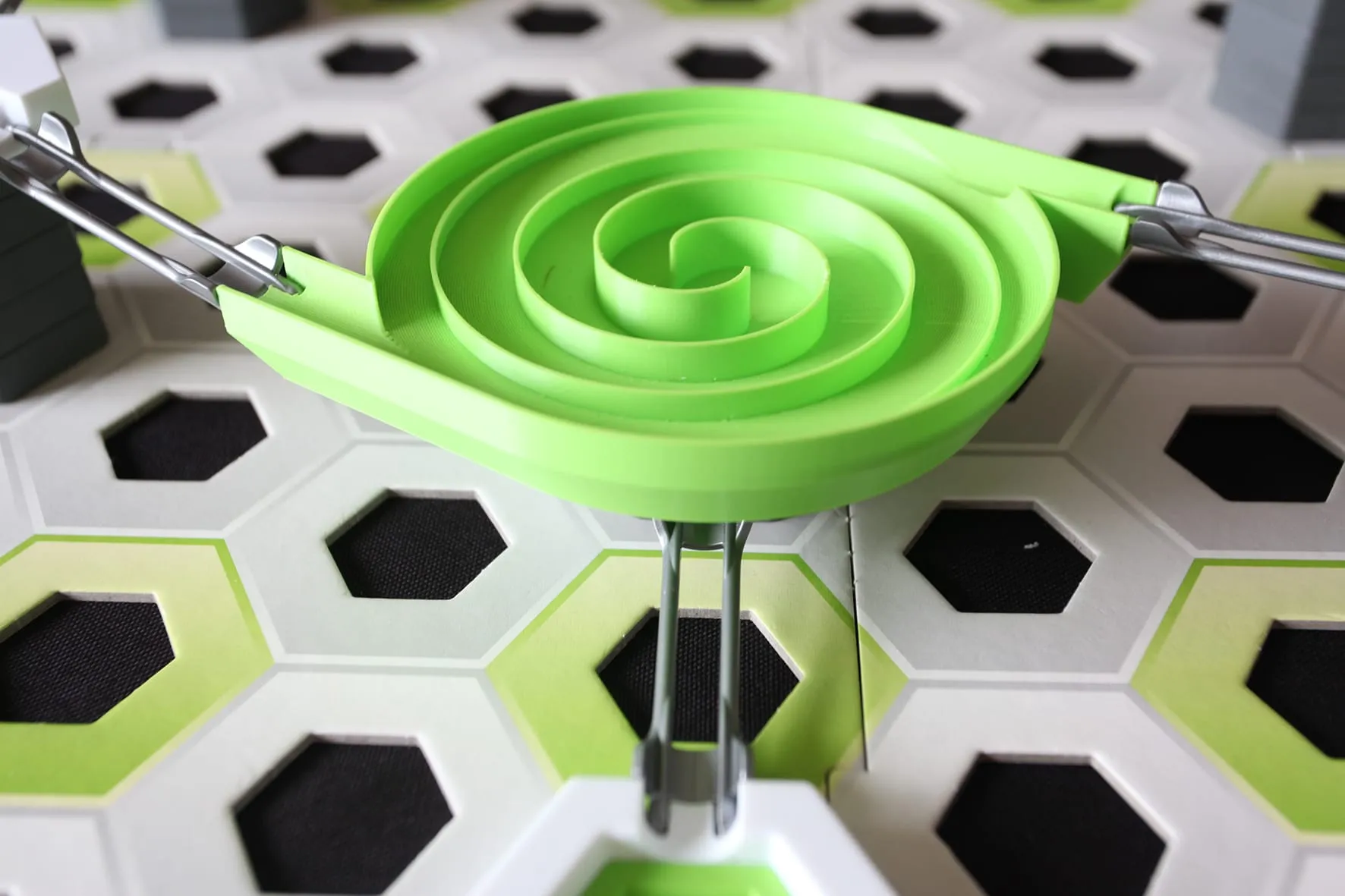 Toupie escargot verte à piste en spirale dans un circuit GraviTrax, vue de trois quarts