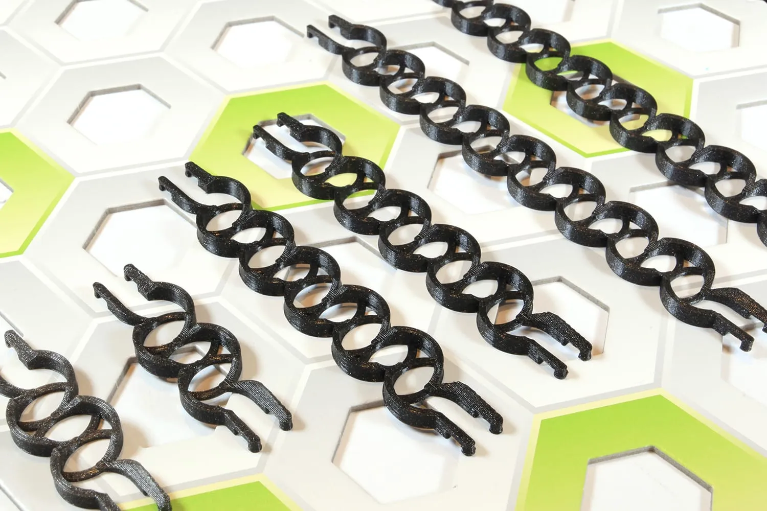 Rails zigzag noirs de plusieurs tailles posés sur une plaque GraviTrax