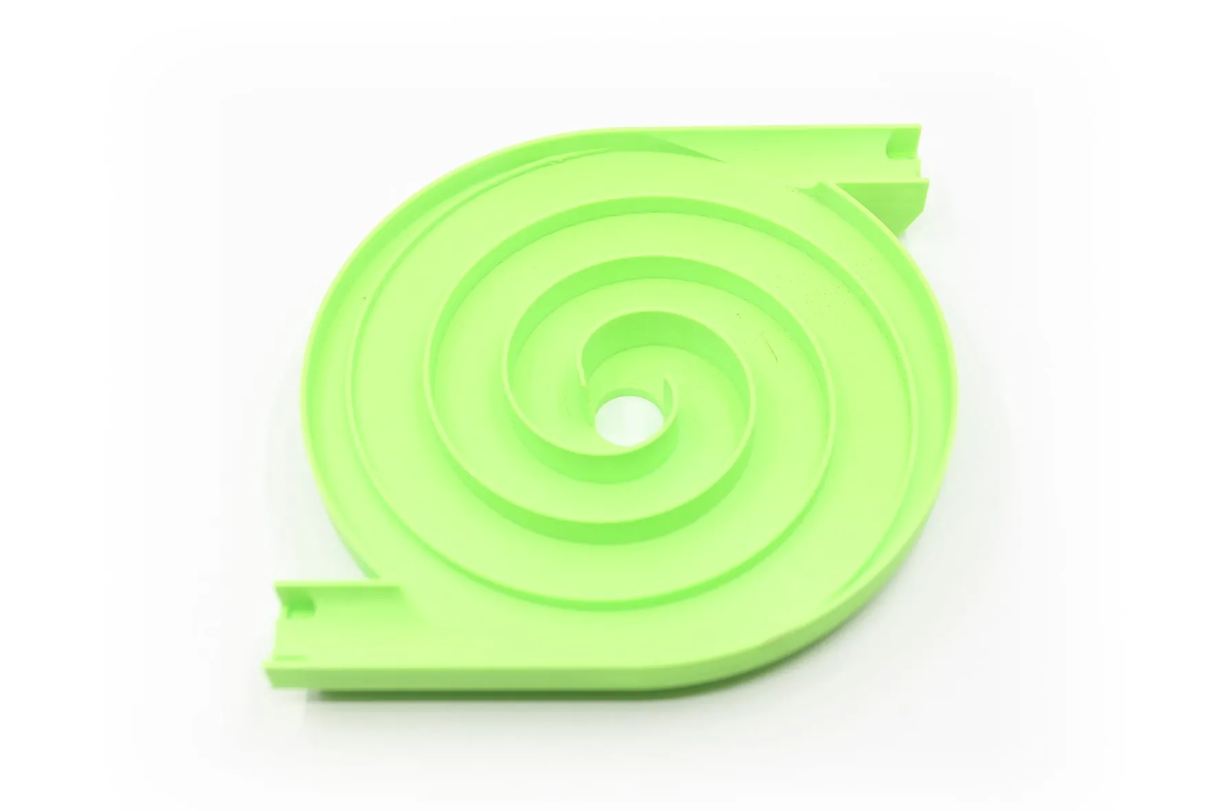 Toupie escargot verte à piste en spirale, vue de trois quarts sur fond blanc