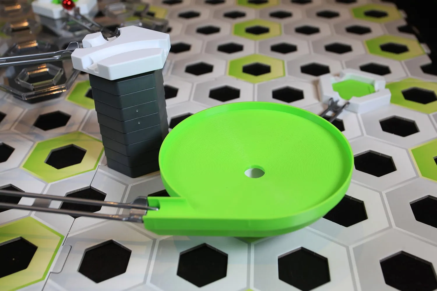 Méga toupie verte à côté d’une tour grise dans un circuit GraviTrax