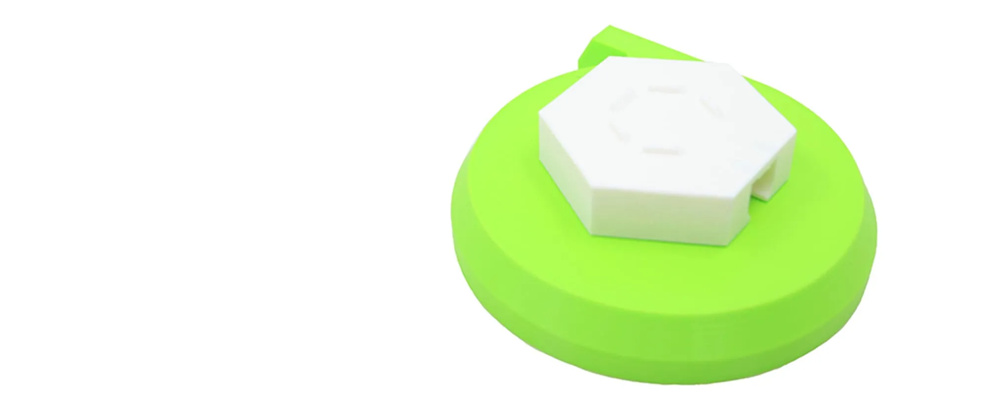 Méga toupie verte posée sur son support blanc hexagonal