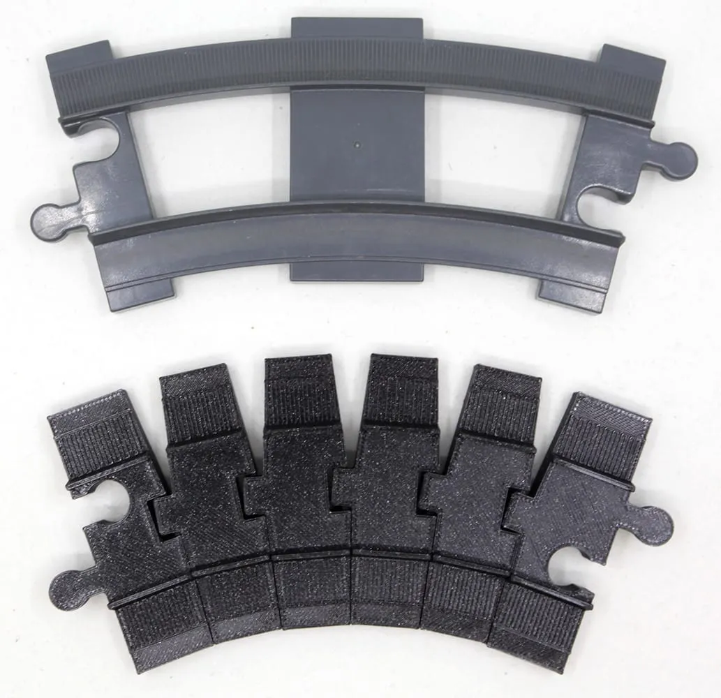 Rail courbe DUPLO gris au-dessus d’un rail flexible noir plié selon la même courbure