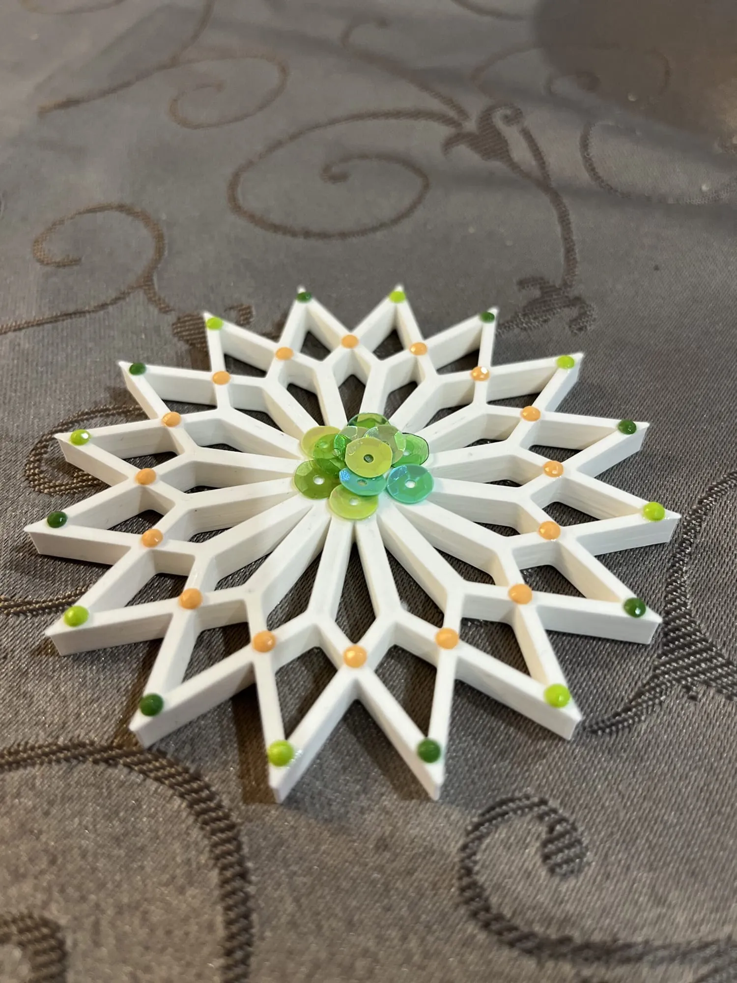 Étoile blanche à nombreuses pointes décorée de points colorés et de paillettes vertes