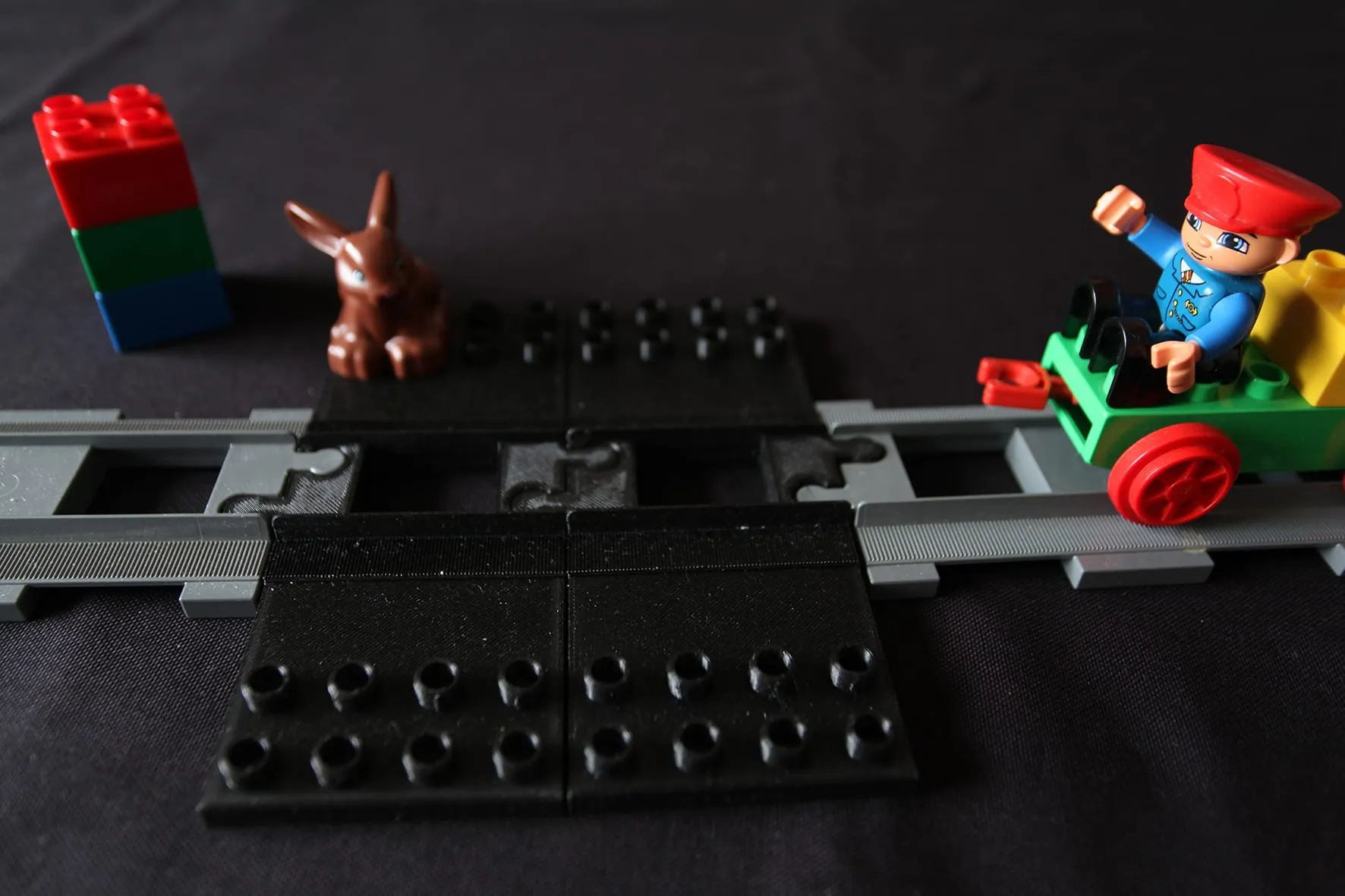 Train DUPLO vert approchant de la plaque noire posée sur les rails